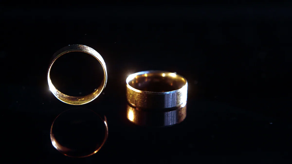 An open-band silver ring slightly unfolded on a charcoal tile, the gap at the back clearly visible.