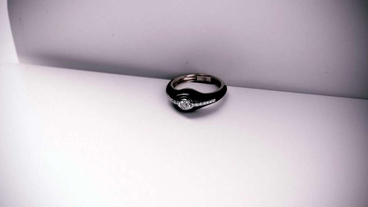 A thick, heavily textured silver ring lying flat on dark ground, its chunky profile lit from above.