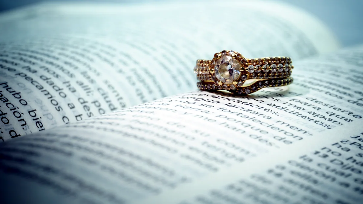 A silver ring placed on a folded paper receipt, the printed lines of text blurred beneath the cool studio light.