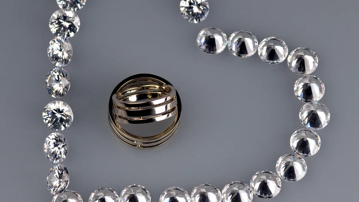 A silver ring with a small heart-shaped cutout at the top, photographed at an angle on dark ground.